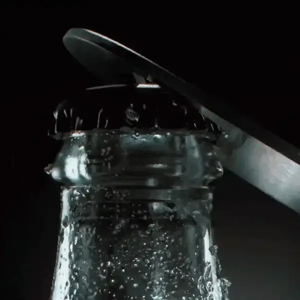 Animated gif of a coke bottle opening and CO2 bubbles forming.